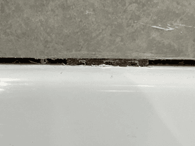 Gap between shower base and tiles requires repair